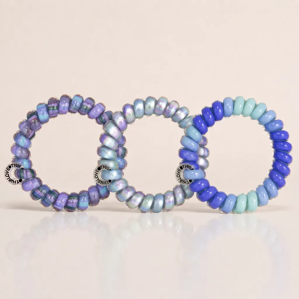 Three blue and lavender Jelly Spiral Hair Ties featuring striped, gradient and mixed colour coil designs.