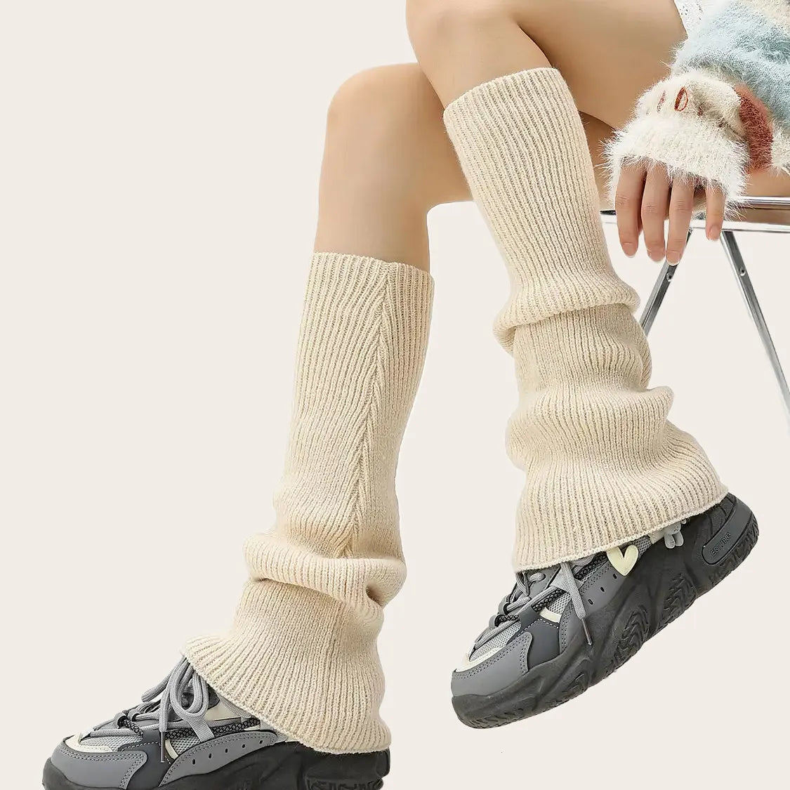 Cream-colored over-the-knee knit leg warmers, styled for feminine fall outfits.