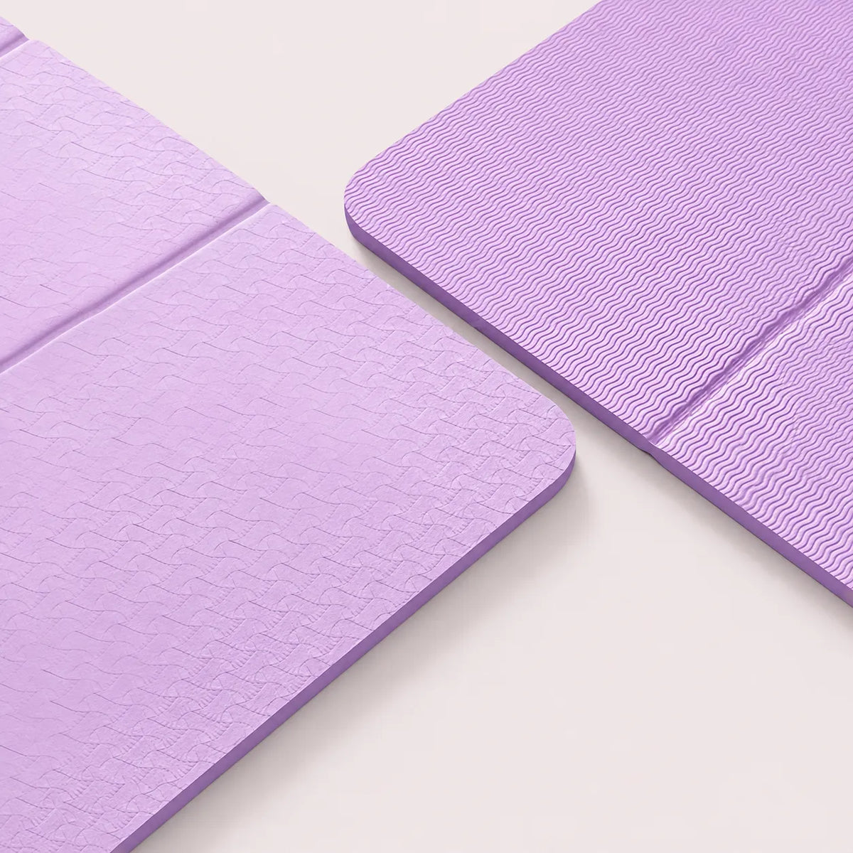Close-up of a light purple folding TPE yoga mat with double-sided textured surfaces