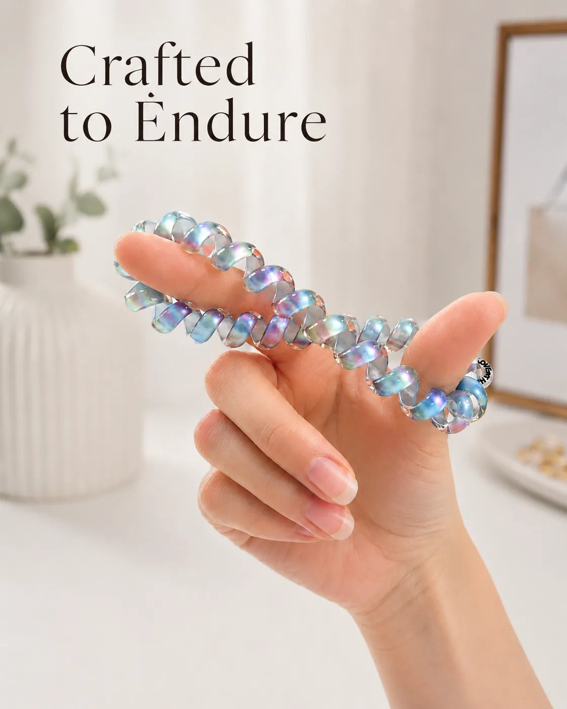 Flexible pink and blue TPU Jelly Spiral Hair Tie stretched by hand to show its soft, resilient coil design.