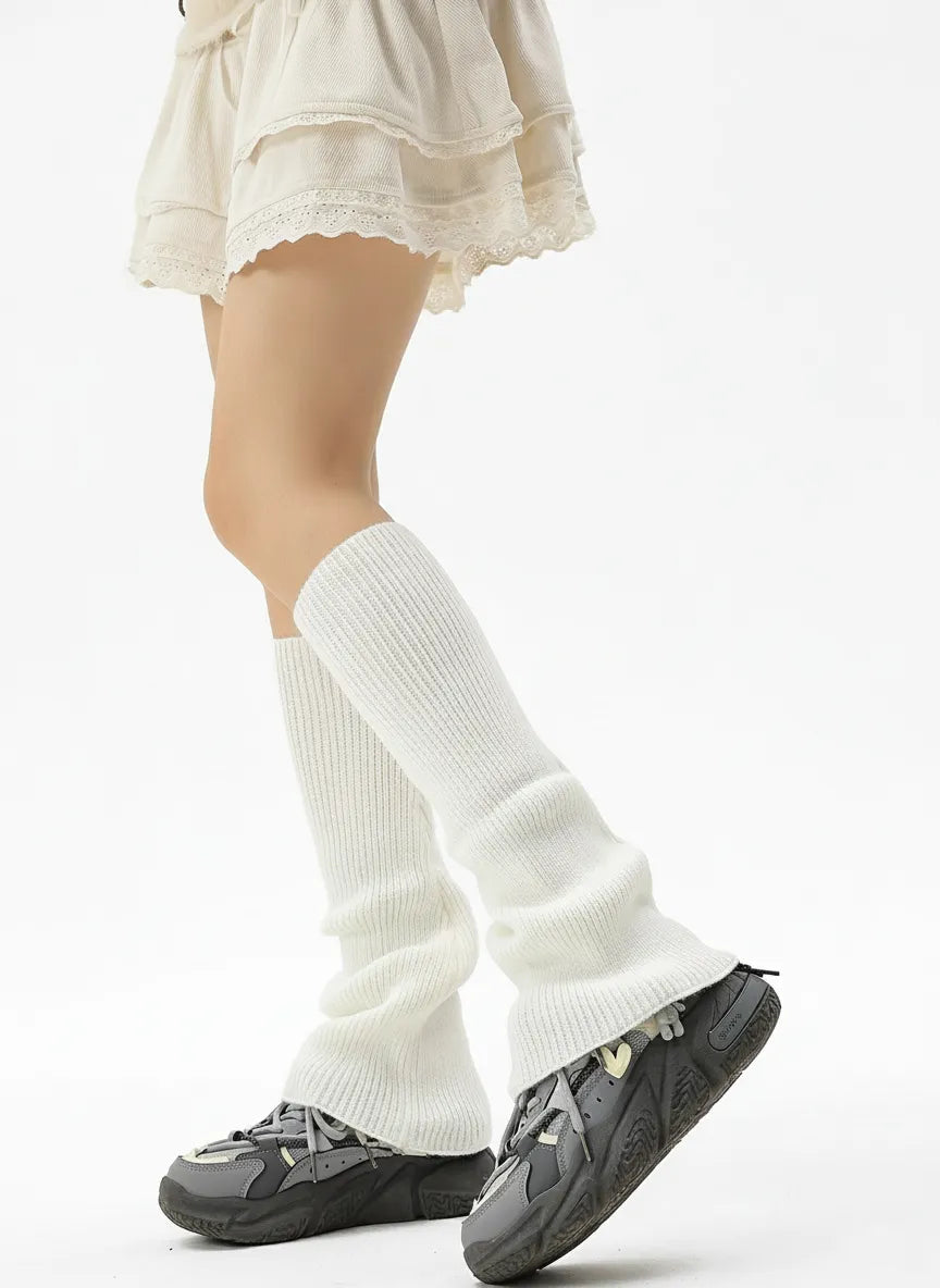 Off-white ribbed knit leg warmers with sneakers; slouchy fit and feminine lace-trim skirt for everyday layering.