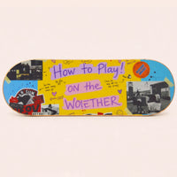 Sportive Lives wooden balance board featuring a colourful yellow collage and graffiti-style decorative sticker design.