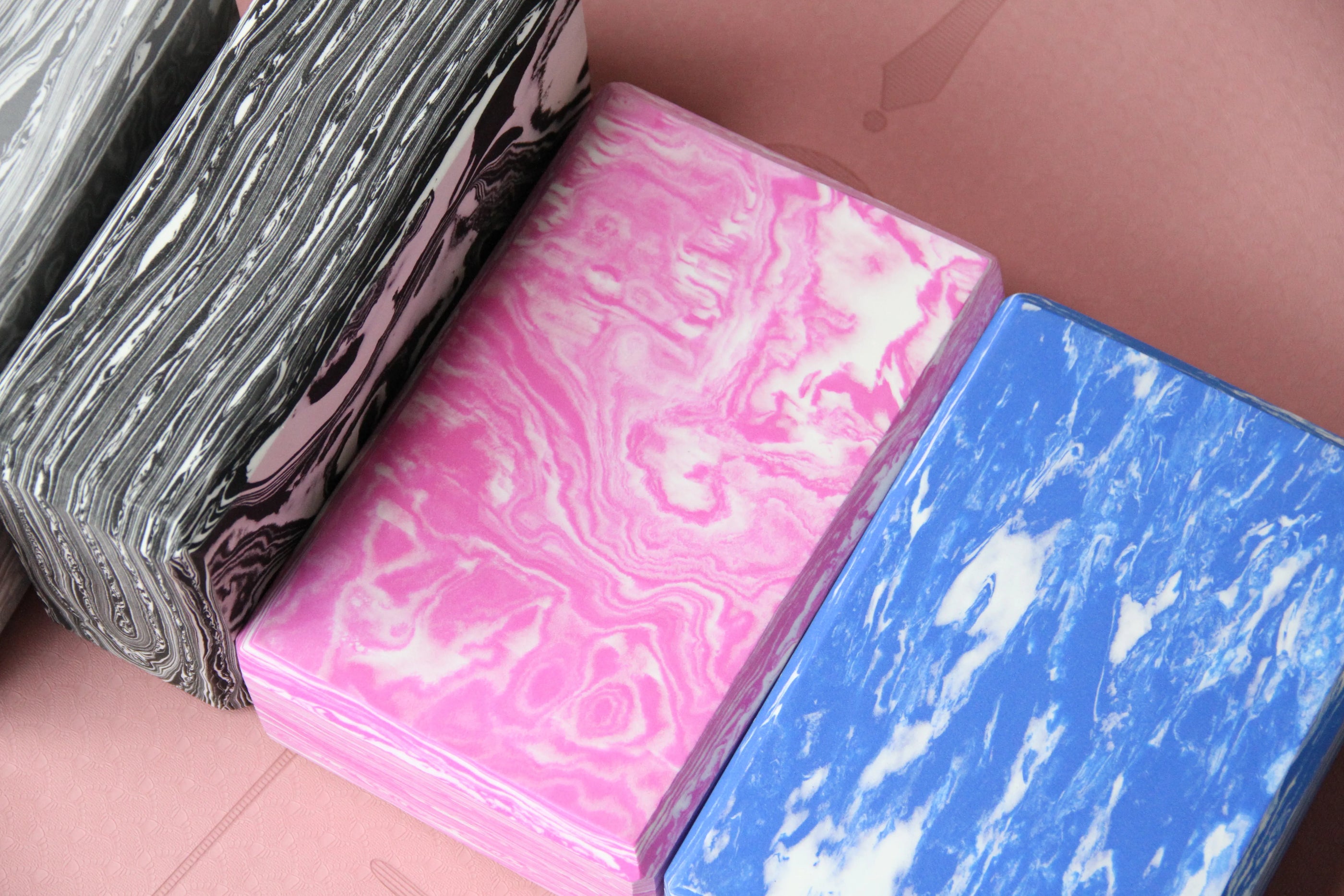 Closeup of Sportive Lives yoga blocks in black, pink, and blue camouflage patterns used on yoga mat, ideal for pose support and stretching in Canada.