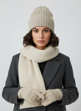 Woman wearing sand beige high rib-knit cuffed beanie by Sportive Lives with matching scarf and gloves; soft stretch acrylic winter knit hat.