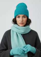 Woman in teal blue high rib-knit cuffed beanie by Sportive Lives with matching scarf and gloves; cozy winter hat, unisex 56–58 cm.