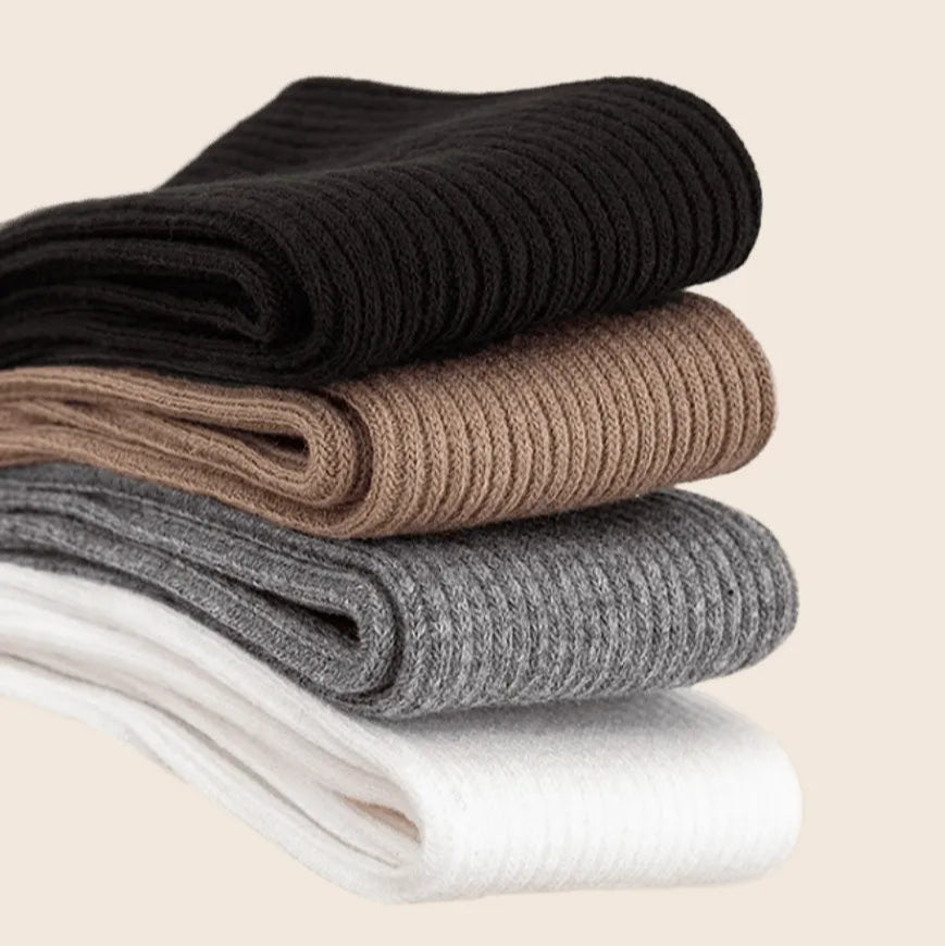 Stack of neatly folded Sportive Lives knee-high socks emphasizing the soft and breathable cotton-rich material in neutral shades.