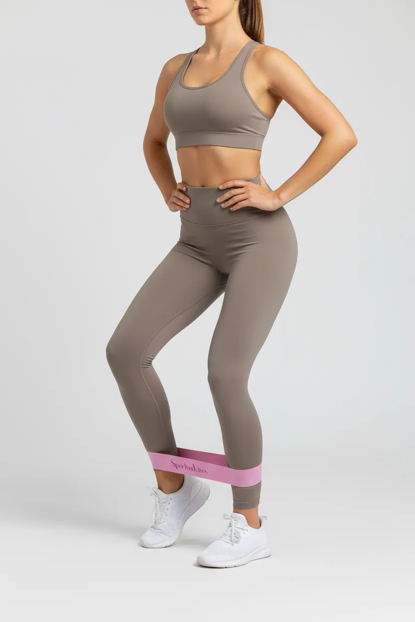 Standing lateral stance with Sportive Lives pink resistance band at ankles for hip abduction and leg shaping