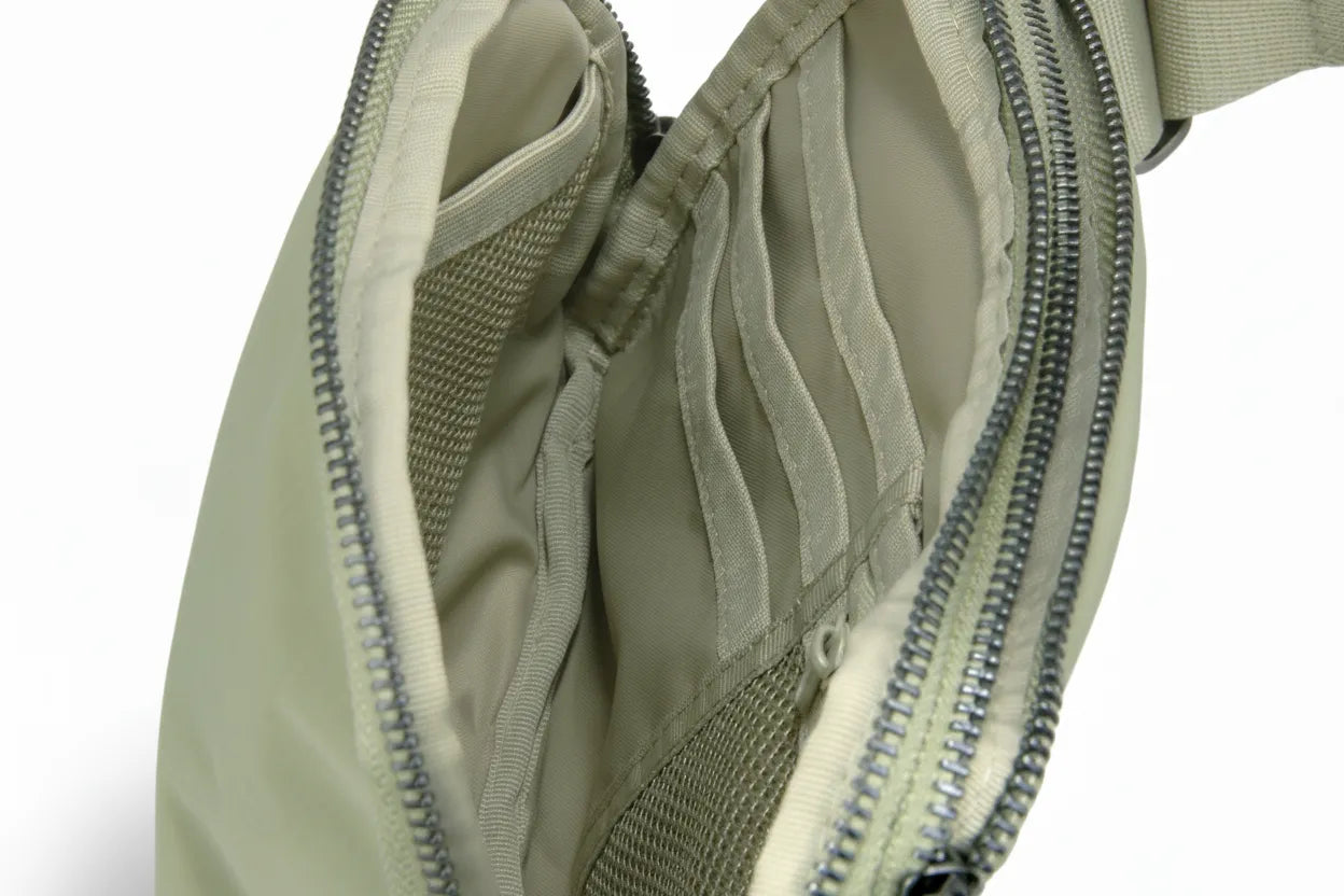 Interior of the sage belt bag highlighting multiple card slots and a breathable mesh pocket for tidy storage.