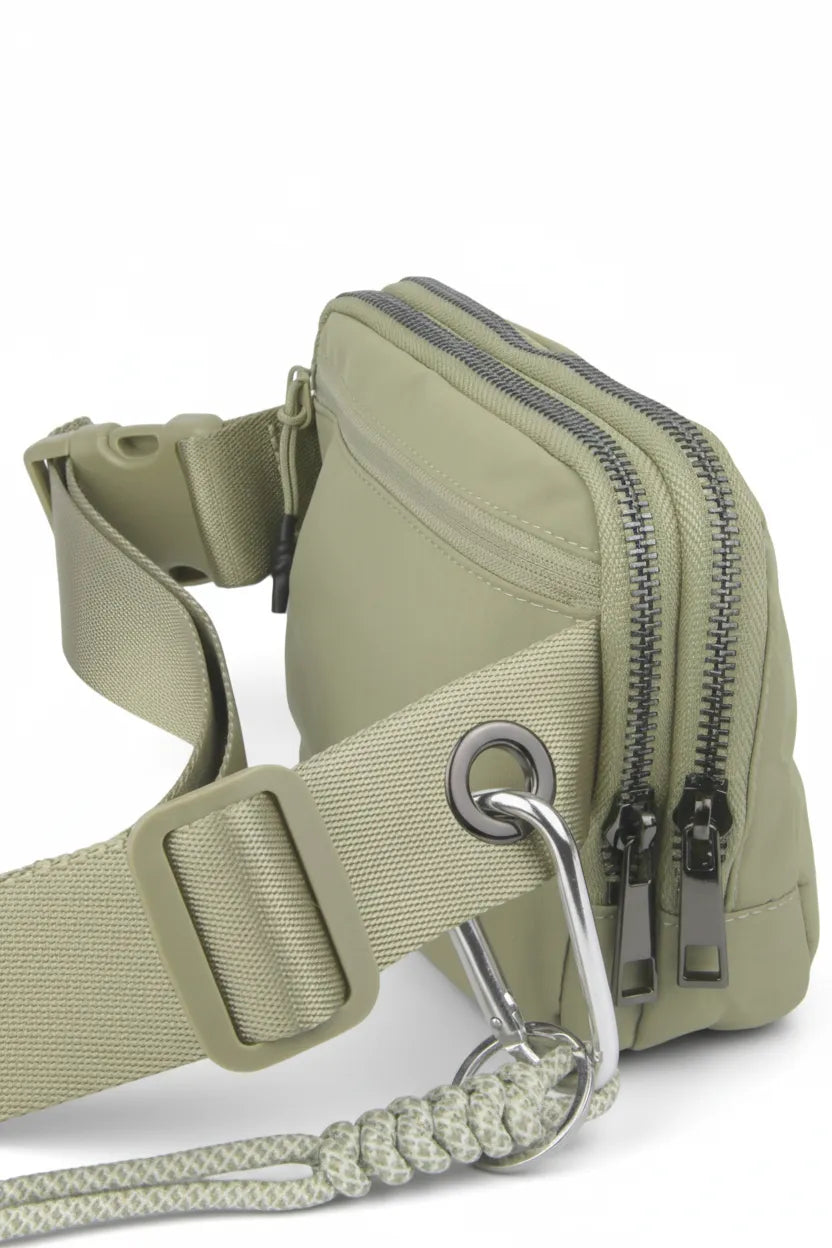 Dual-zip compartments and carabiner loop on the sage waterproof nylon belt bag for flexible organization.
