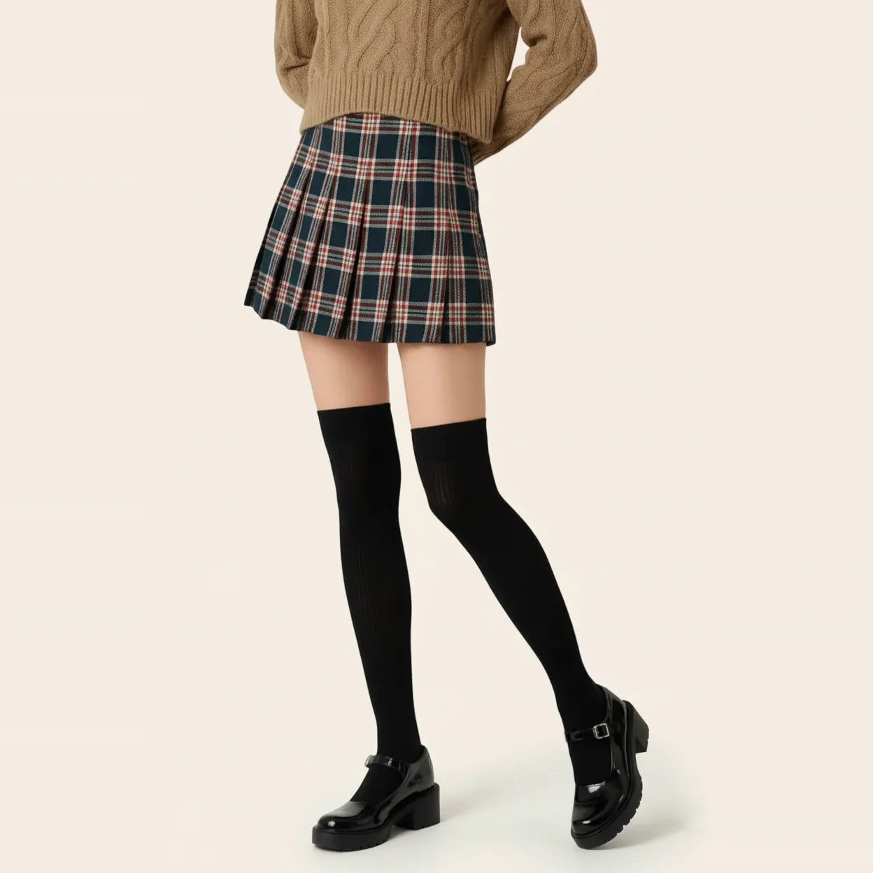 Woman wearing black ribbed over-the-knee socks with a plaid pleated skirt, brown cable-knit sweater and black Mary Jane shoes.