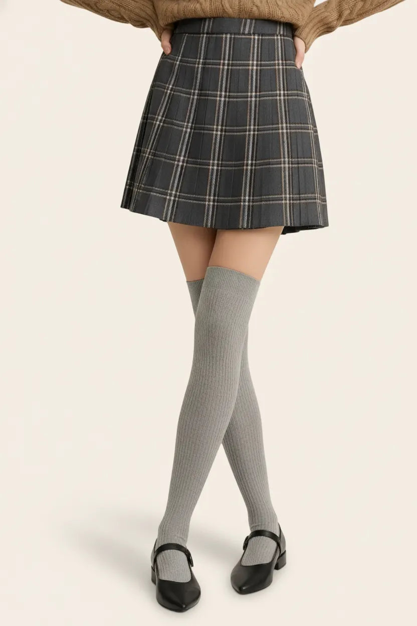Heather grey ribbed thigh-high socks for women, soft knit, paired with grey plaid skirt.