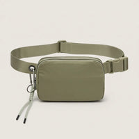 Front view of an olive water-resistant nylon belt bag with adjustable strap, dual zippers and a detachable carabiner key clip.